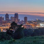 The Saint Paul skyline at dusk with golden city lights reflecting off the Mississippi River, showcasing the Twin Cities’ vibrant nightlife and urban elegance.